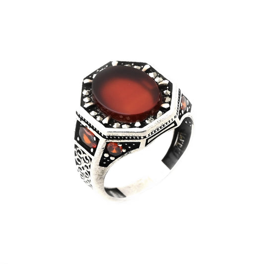 خاتم فضة رجالي عيار 925 بحجر عقيق بني بيضاوي الشكل ومطعم بأحجار ماركزت على الوش واحجار زركون احمر شكل دائري وبيضاوي بالجانبين